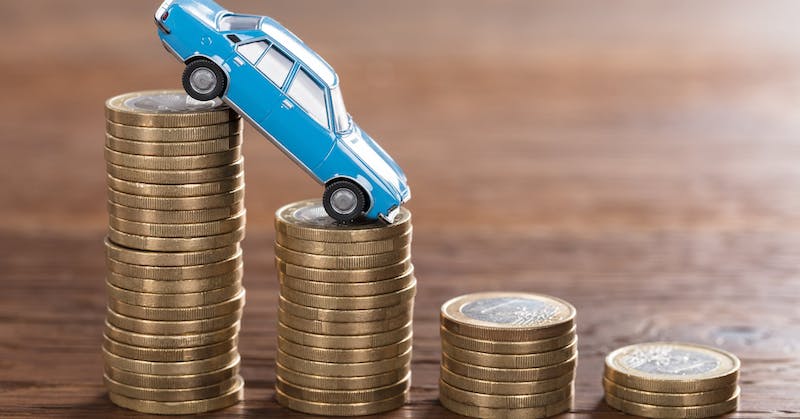 Close-up,Of,A,Car,Model,Over,A,Stacked,Coin,At