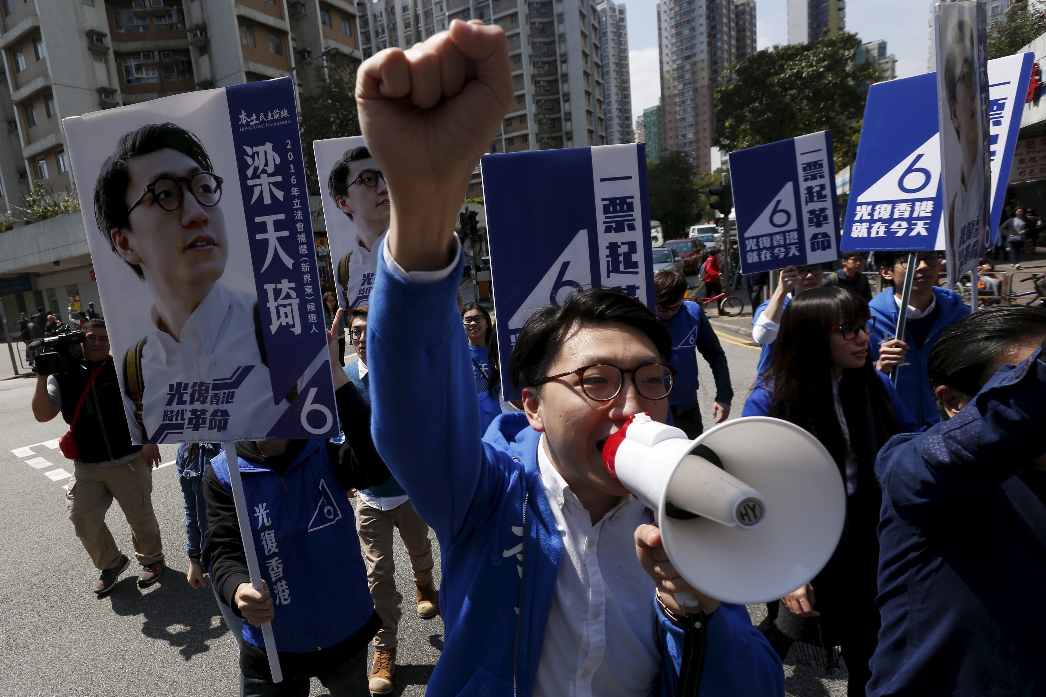Edward Leung, a candidate from the Hong Kong Indigenous, chants slogans while crossing a street at a campaign during a Legislative Council by-election in Hong Kong