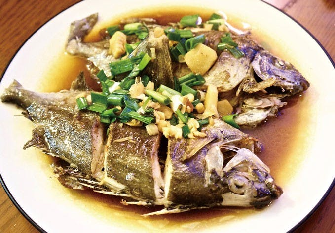 The piece de resistance of the meal: pan-fried fish with garlic, ginger, and scallions. Photo Credit: Jules Quartly/Taiwan Business TOPICS