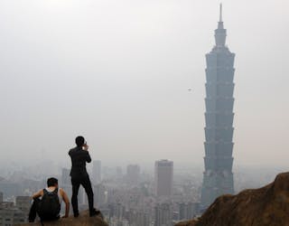 Men look at the Taipei 101 building from Elephant Mountain in Taipei