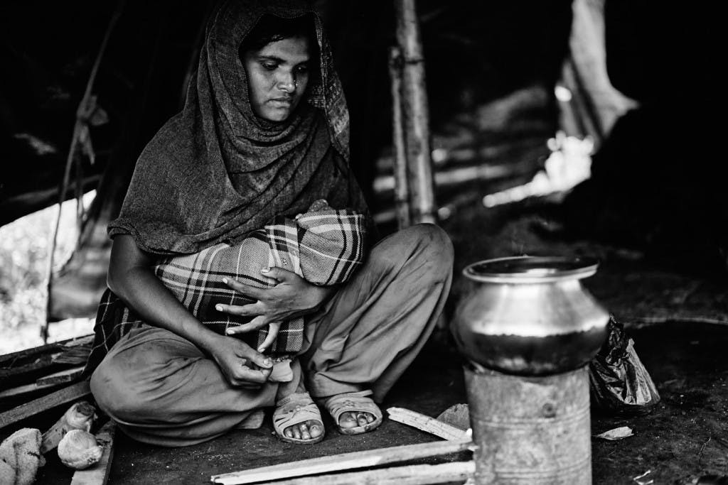 家中的母親與嬰兒，她正為了在加德滿都加上工作的丈夫準備食物。