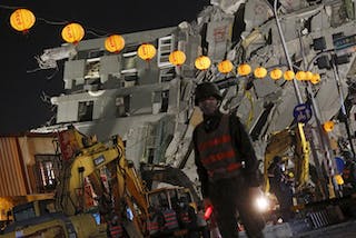 Soldiers stand guard in front of 17-storey apartment building collapsed after an earthquake, on the first day of the Chinese Lunar New Year at Tainan, southern Taiwan
