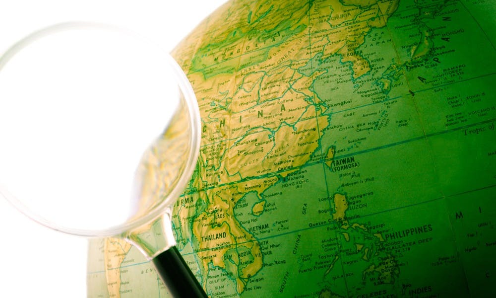 A green globe with a magnifying glass