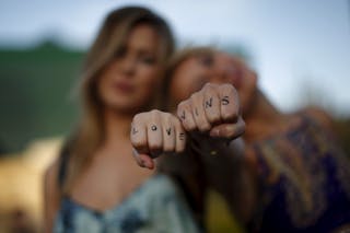 Cherilyn Wilson, 26, and Chelsea Kane, 26, display their fists as they pose at a celebration rally in West Hollywood