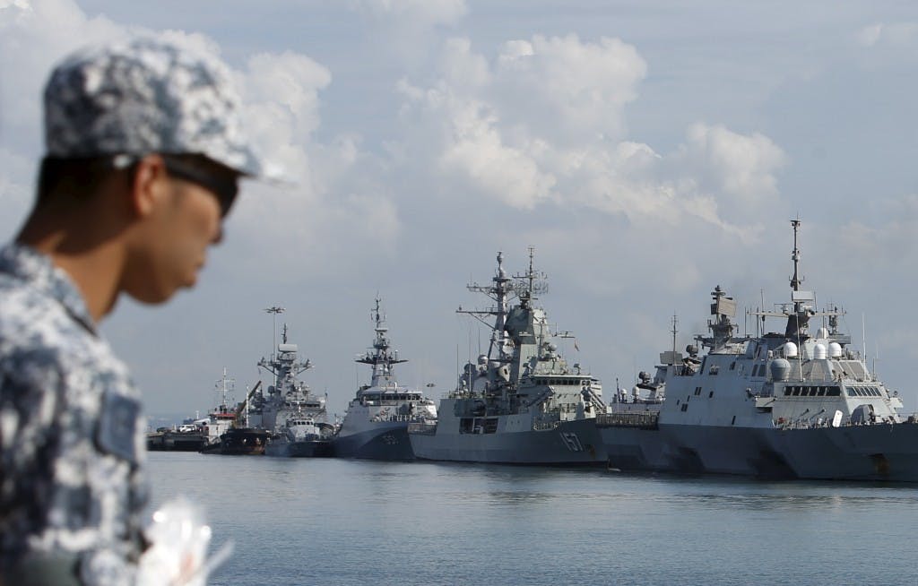A Singapore navy serviceman passes a display of warships ahead of the IMDEX Asia maritime defence exhibition at Changi Naval Base in Singapore