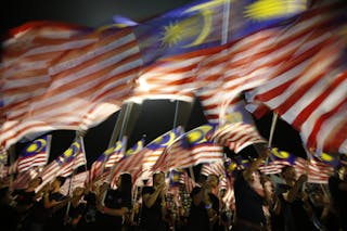 Locals from Sabah wave Malaysian flags during the Malaysia Day celebrations marking Sabah's entry into Malaysia, in Kota Kinabalu