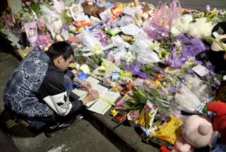 女童斷頭案 隨機殺人 A man leaves a message on a memorial book at a makeshift memorial near the site where a girl was found decapitated, outside a metro station, in Taipei, Taiwan