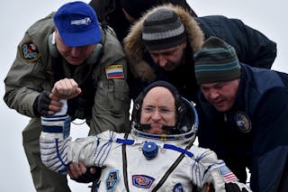 Ground personnel help U.S. astronaut Scott Kelly to get out of a Soyuz capsule shortly after landing near the town of Dzhezkazgan