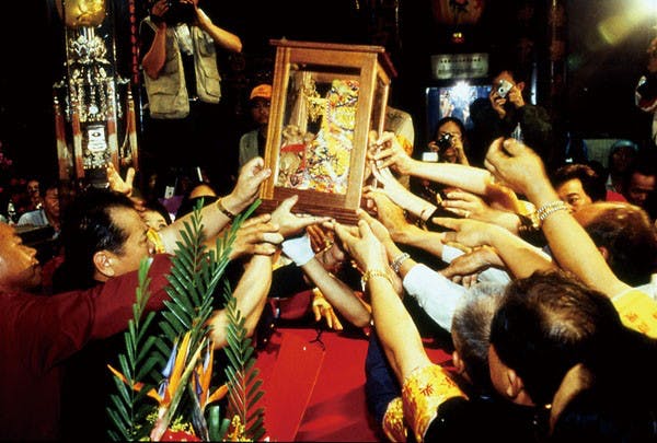 A Matsu effigy is passed through a crowd of worshippers during a ceremony. (Photo: Tourism Bureau)