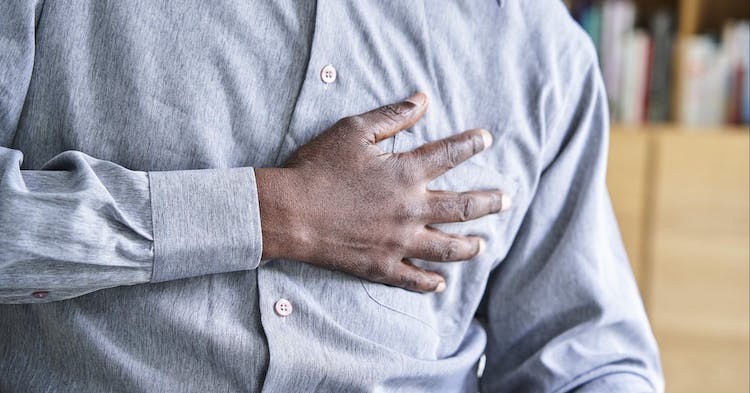 Close-up view of African-American man holding his chest in pain