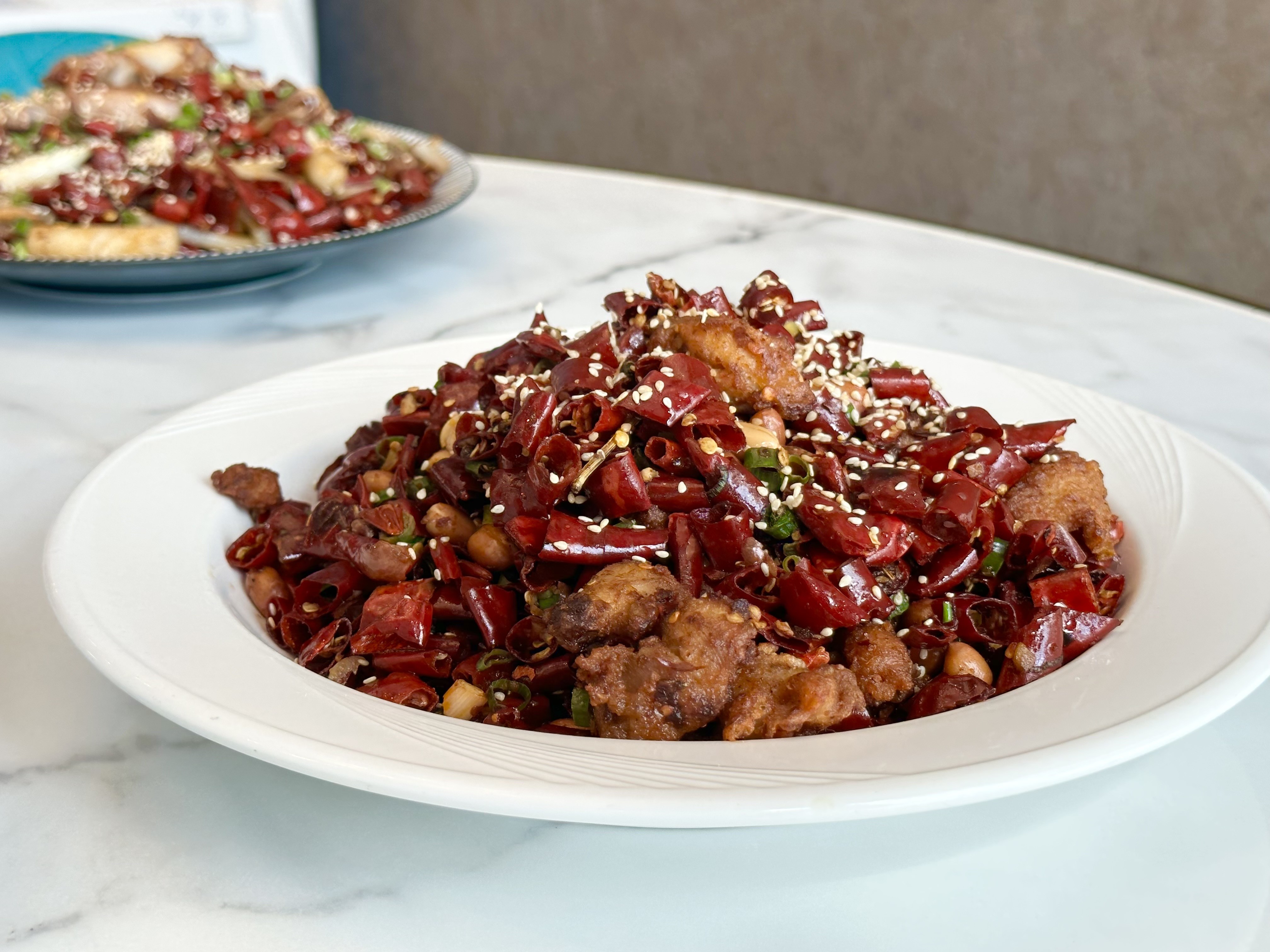 「歌樂山辣子雞」用大量成都進口的乾辣椒，爆炒酥炸過的雞腿肉，麻辣重味，十分下飯。（398元／份）