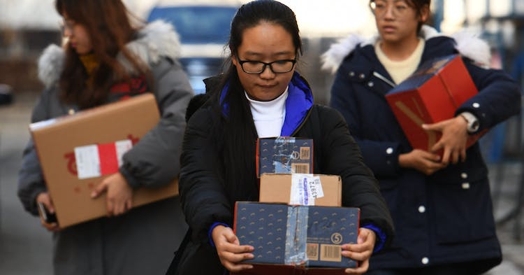 HARBIN, CHINA - NOVEMBER 14: Chinese college students wait to get Singles' Day shopping parcels as the outdoor temperature reaches minus 4 at a temporary tent at Heilongjiang University on November 14, 2018 in Harbin, China. Chinese college students become a major force in Singles' Day sales during the 10-year-old Tmall Singles' Day festival created by Chinese e-commerce giant Alibaba, which falls on November 11. It has reached a new high with 213.5 billion yuan ($30.67 billion) of sales and 1.04 billion express packages this year. (Photo by Tao Zhang/Getty Images)