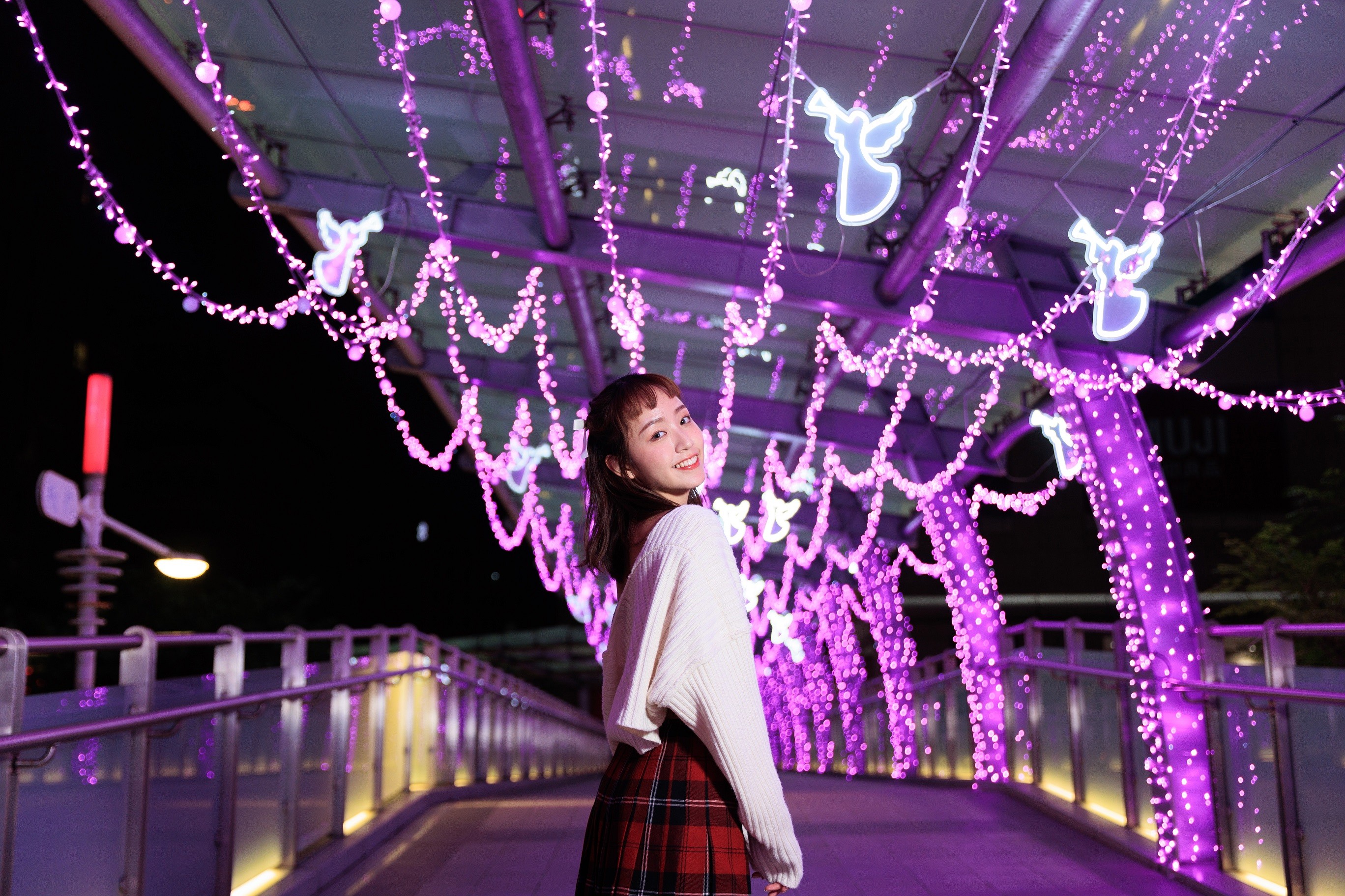 「心願光廊」紫色系耀眼燈串天橋設計穿插閃耀著白光的天使，傳遞耶誕祝福。（新北觀旅局提供）