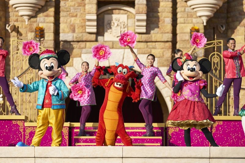 換上龍年新衣的米奇、米妮與木須龍在城堡舞台上為大家演出春節特別節目。（香港迪士尼樂園提供）