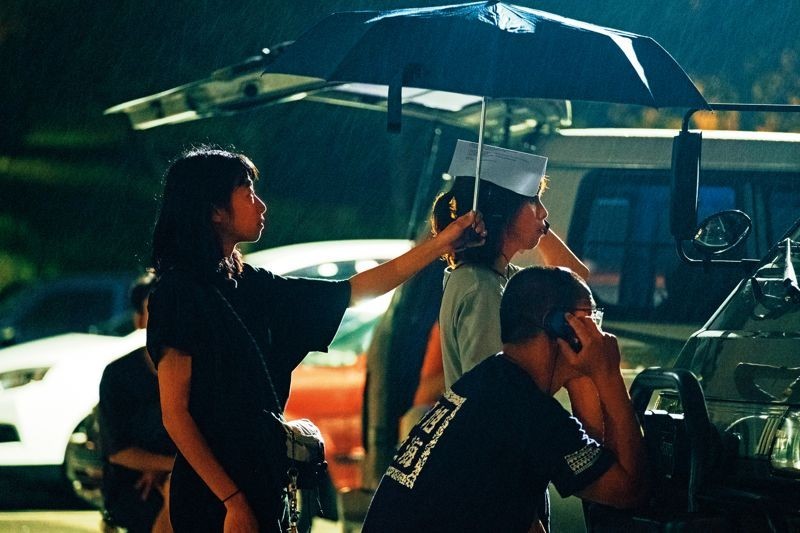 	方夢貞（左二）與拍攝團隊在雨中等待，耐心觀察。（公視提供）
