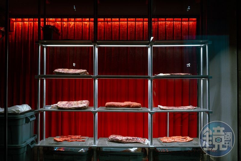 以紅幕映襯的韓牛，在玻璃隔開的熟成室中，如藝術品般呈現。