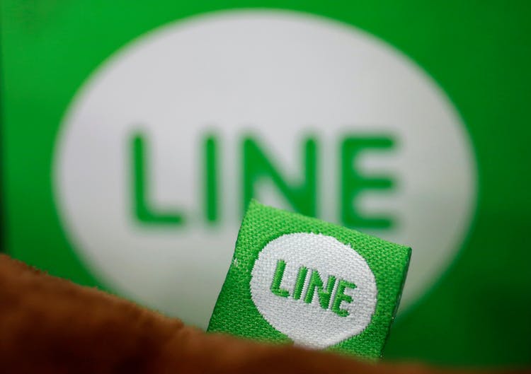 The logo of free messaging app Line is pictured on a smartphone and the company's stuffed toy in this photo illustration taken in Tokyo