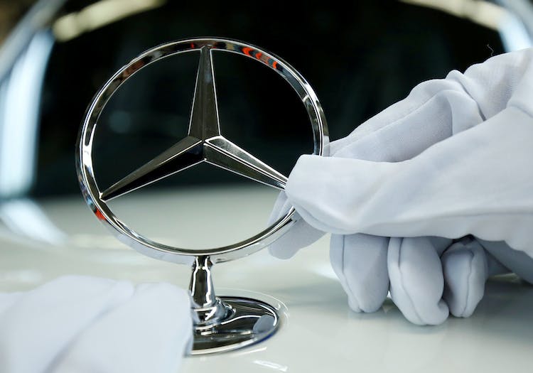 FILE PHOTO: An employee of German car manufacturer Mercedes Benz installs the brand's characteristic star on a Mercedes S-Class (S-Klasse) at a produc...